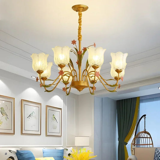 Wide view of a gold floral ceramic chandelier with multiple arms and glass shades in a living room setting.