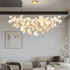 Gold ginkgo leaf cluster pendant light hanging above a sofa in a modern living room