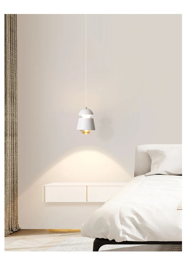 Modern bedroom with a bed, nightstand, and pendant light.