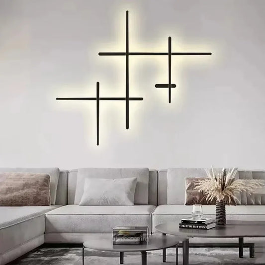 Cluster of black geometric line wall lights mounted on a white wall above a light-colored sofa.