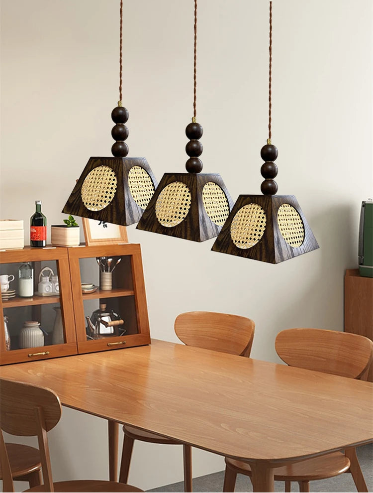 Three pendant lights hanging above a wooden dining table with chairs.