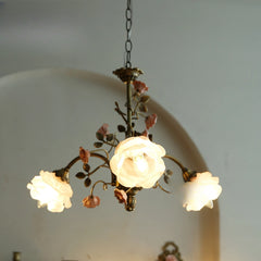 A brass chandelier with illuminated frosted glass shades, showcasing its floral design.