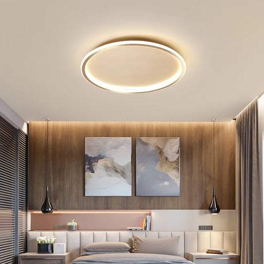 Close-up view of a modern black circular flush mount ceiling light in a bedroom.