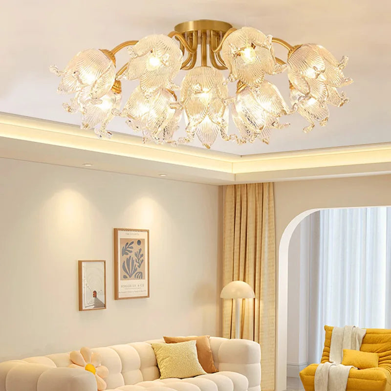 A living room scene with a gold semi-flush ceiling light with glass floral shades providing ambient lighting.