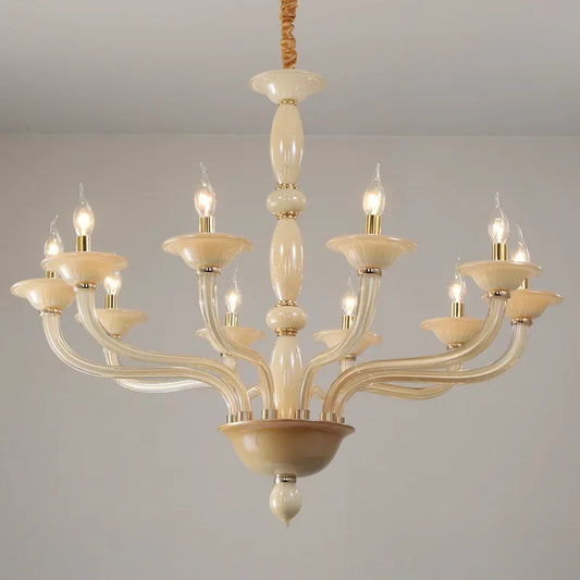 Close-up view of a champagne ceramic and glass chandelier with candle-style bulbs, showcasing the arm curvature and central column.