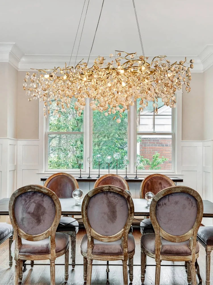 Dining room with a large ornate chandelier, table, and chairs.
