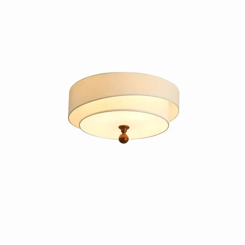 Ceiling light fixture with beige shade and gold fixture on a white background