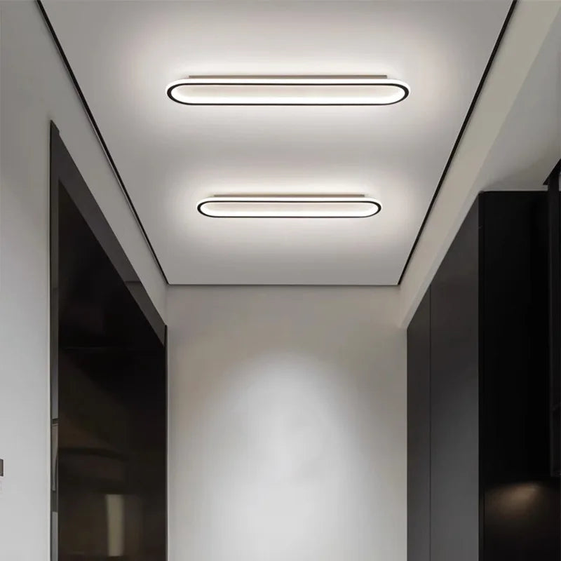 A modern hallway with two oval flush mount ceiling lights on the ceiling.