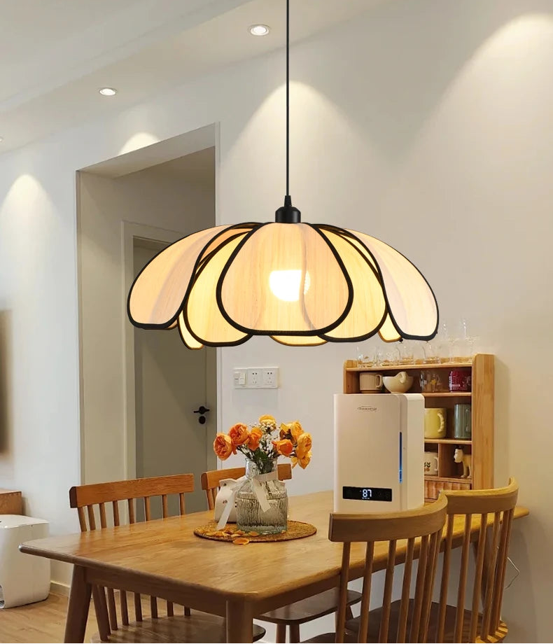 Dining room with a pendant light fixture, wooden table, and chairs.