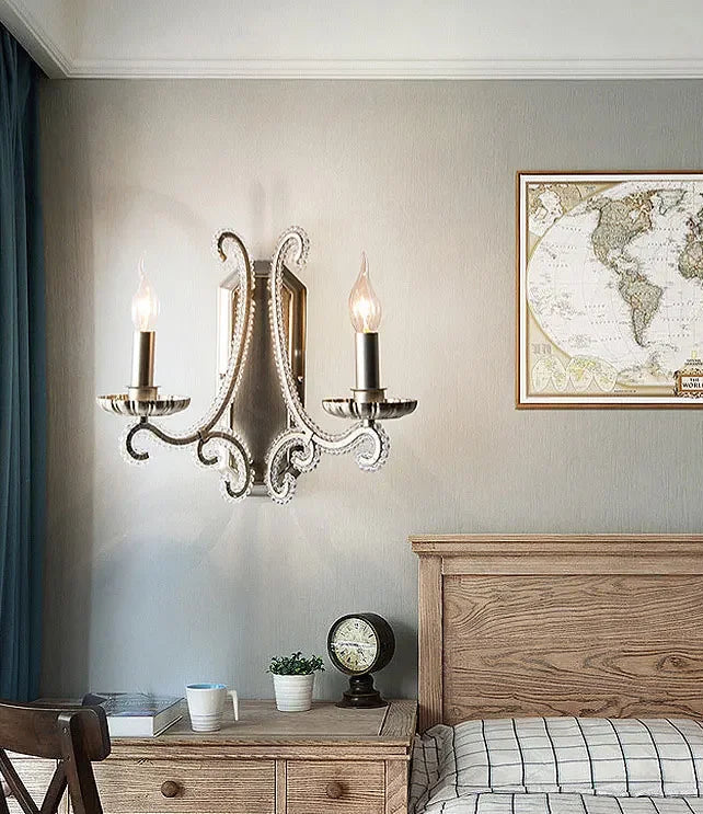 Decorative wall sconces above a wooden nightstand with a world map on the wall.
