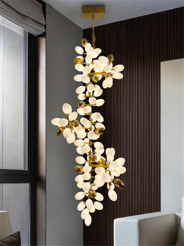 Decorative chandelier with white floral lights and gold accents in a modern interior setting.