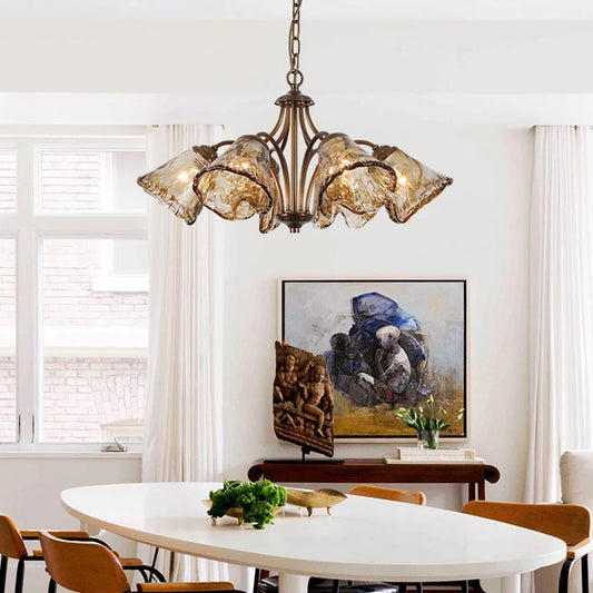 Dining room featuring a copper floral chandelier with smoked glass shades above an oval table.