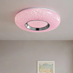 Circular flush mount ceiling light with a textured pink surround and a central chrome ring, studded with small sparkling lights.