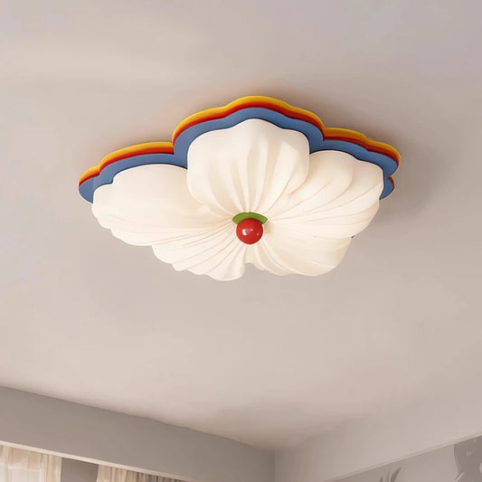 White flower-shaped flush mount ceiling light with multicolor accents on a white ceiling.