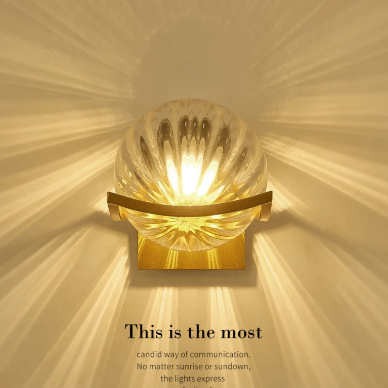 Decorative wall light with a gold frame and glass shade on a beige background.