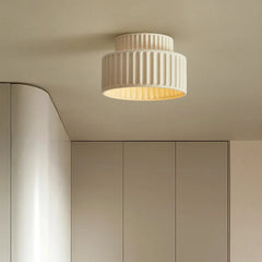 White flush mount resin light with ribbed texture on a neutral ceiling