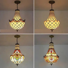 A close-up of the detailed stained glasswork on a pendant light, featuring a polished chrome metal base and hanging hardware.