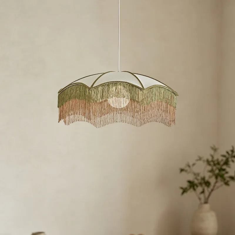 Close-up of the white fabric pendant light with layered tassels and gold trim