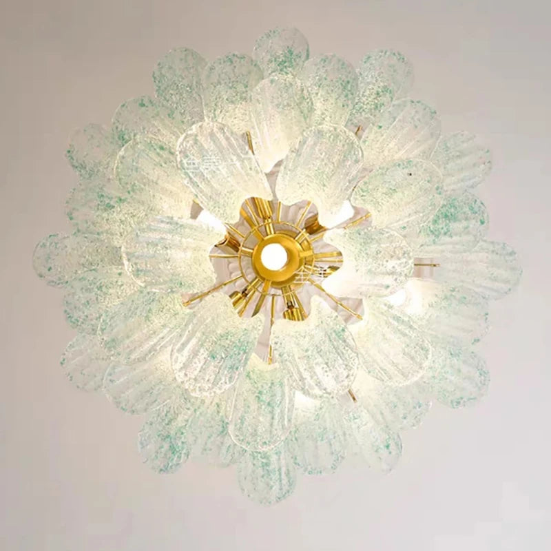 Top-down view of a gold chandelier with numerous light green speckled glass elements arranged in a floral pattern.