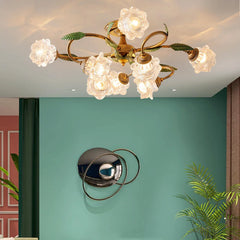A gold multi-arm ceiling light with clear, faceted glass shades and green leaf accents, installed on a ceiling in a room with teal walls.