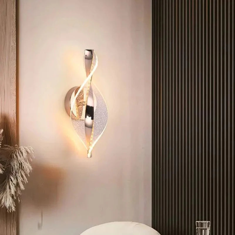 Modern wall sconce on a wall with a decorative plant and striped wall in the background