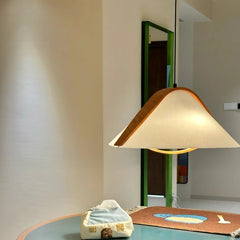 Fabric cone pendant light with wood accents hanging over a table with a tissue box.