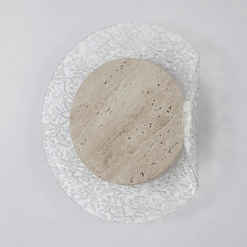 Round stone-like object on a textured glass plate against a light gray background
