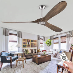 Wooden three-blade ceiling fan with a brushed nickel mount, displayed in a contemporary living room with a remote control in hand.