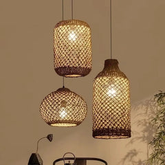 Three woven bamboo pendant lights in various cylindrical and spherical shapes hanging against a dimly lit background.