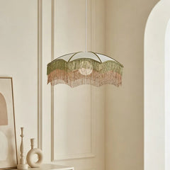 White fabric pendant light with layered tassels hanging in a room setting