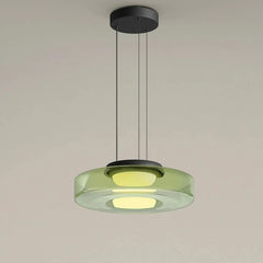 Green glass disk pendant light with a black ceiling mount and cord.