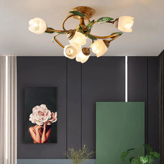 A gold multi-arm ceiling light with white tulip-shaped glass shades and green leaf accents, installed on a ceiling above a dark wall with a floral artwork.
