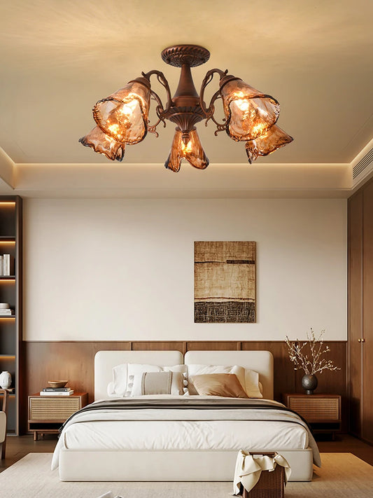 Close-up view of the amber stained glass shades on a brushed bronze floral semi-flush mount ceiling light.