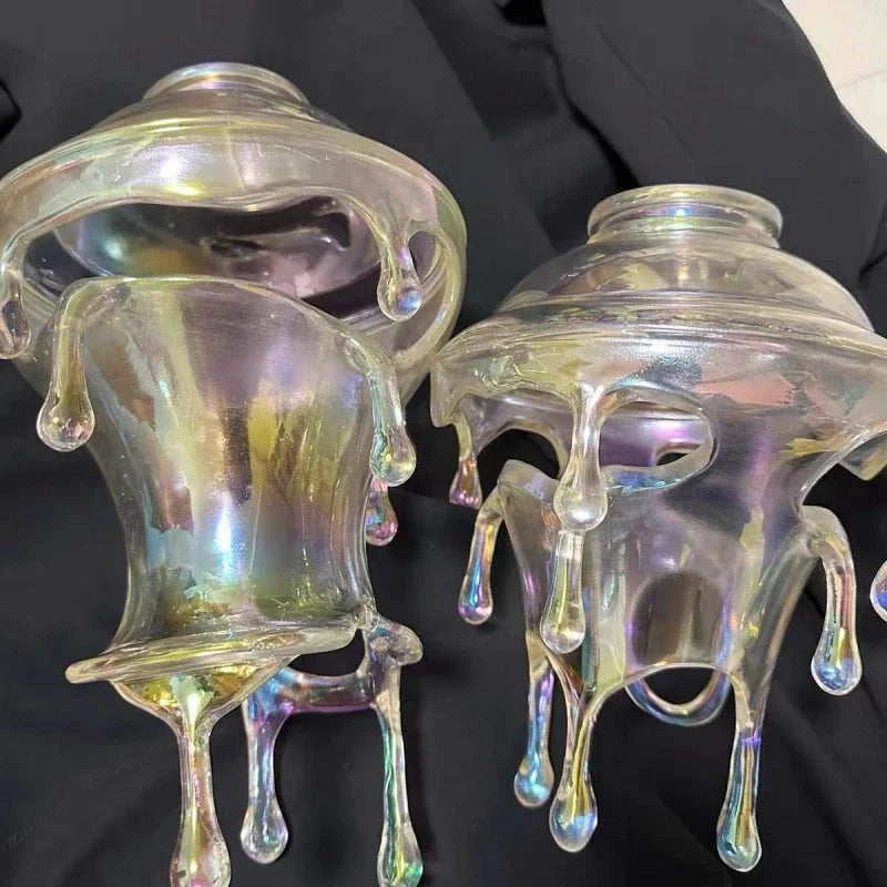 Iridescent glass candle holders on a black background