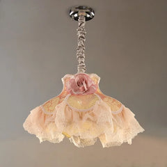 A fabric pendant light with a pink rose and ruffled shades is shown attached to a chrome ceiling mount.