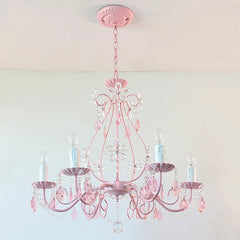 Close-up view of the pink semi-flush mount chandelier, highlighting the crystal flower details and candle-style bulb holders.