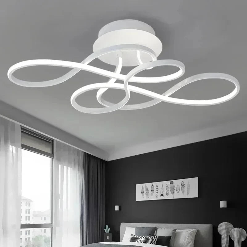 A bright white swirl flush mount ceiling light installed in a modern bedroom.