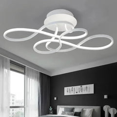A bright white swirl flush mount ceiling light installed in a modern bedroom.