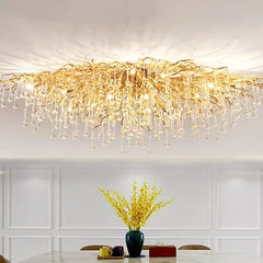 Gold crystal chandelier with cascading teardrop crystals hanging from a gold frame, mounted on a white ceiling.