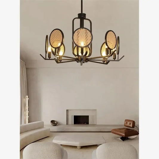 Chandelier with black metal frame and woven rattan discs in a living room setting with a fireplace.