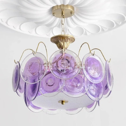 Close-up of the purple glass discs and gold metal frame of the semi-flush chandelier