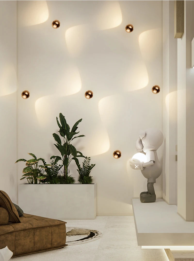 Modern interior with a plant, sculpture, and wall lights.