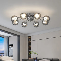 A living room with a large window overlooking a city skyline, featuring a polished chrome starburst chandelier on the ceiling.