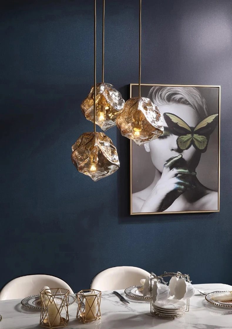 Modern dining setup with crystal pendant lights and a butterfly-themed artwork on a dark wall.