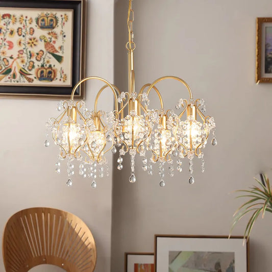 Close-up view of the gold crystal chandelier, highlighting the intricate design of the crystal droplets and the brushed gold metalwork.