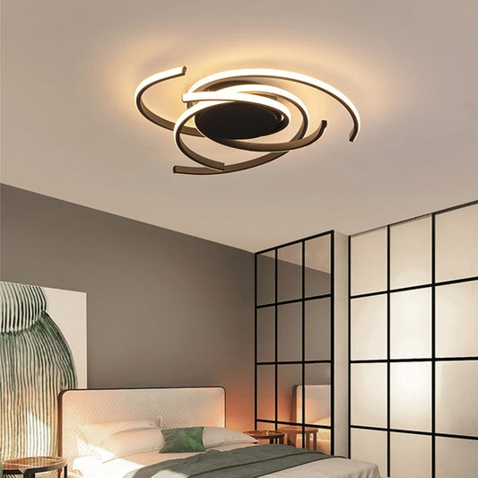 Black spiral swirl flush mount LED ceiling light fixture mounted on a white ceiling in a bedroom setting.