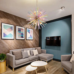 A living room with a sectional sofa and coffee tables, illuminated by a multi-colored starburst chandelier.
