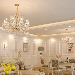 Living room with two gold chandeliers, one large in the foreground, one smaller in the background.