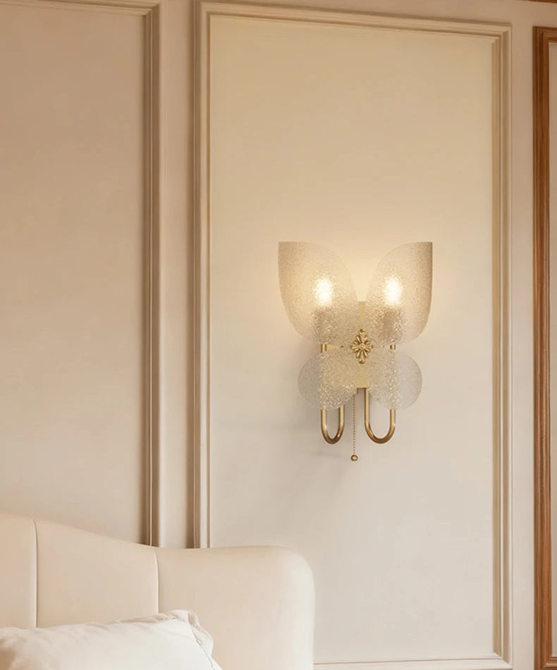 Decorative wall sconce on a wall with a bed in the foreground