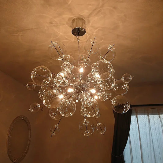 A large glass ball starburst chandelier with multiple clear glass spheres and integrated LED lights, suspended from a chrome ceiling mount.